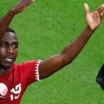 Utilice este título Almoez Ali, el “9 de Qatar” del debate entre Riquelme y Macri en las elecciones de Boca que hoy quiere sorprender en el Mundial 2026 y cree en base a ese titulo original un titulo nuevo, preciso, comprensible y que no pierda relacion con el titulo original. Necesito que me devuelvas solo y nada mas que el titulo nuevo.